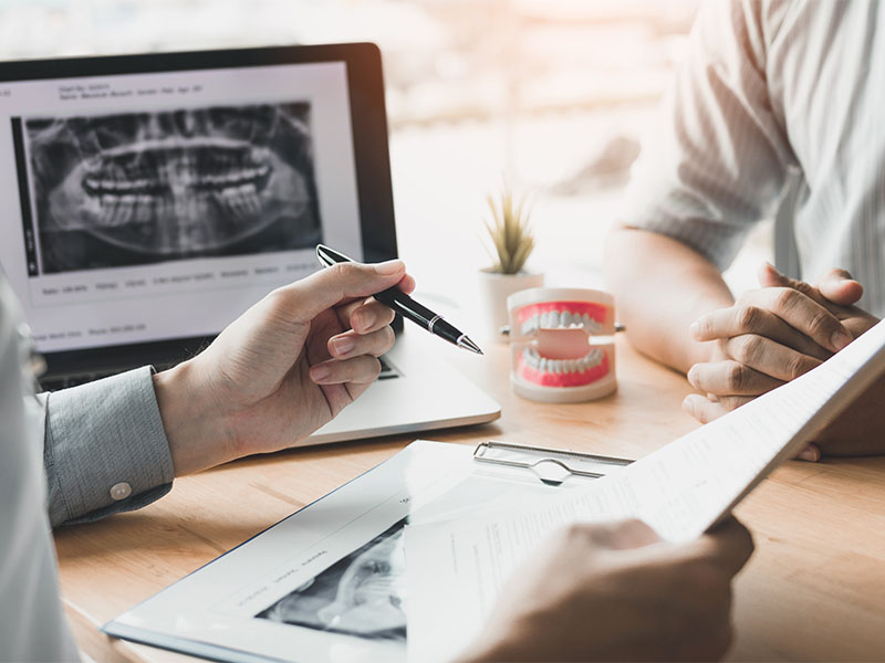 Zahnarzt in Freiburg bespricht Zahnersatz mit Patient